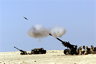 A 155 mm artillery shell is visible as it exits the barrel of an M-198 howitzer during training A 155 mm artillery shell is visible as it exits the barrel of an M-198 howitzer during training