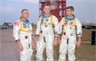Grissom, White, and Chaffee in front of the launch pad containing their AS-204 space vehicle Grissom, White, and Chaffee in front of the launch pad containing their AS-204 space vehicle