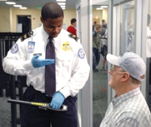 A TSA Officer screening a passenger A TSA Officer screening a passenger
